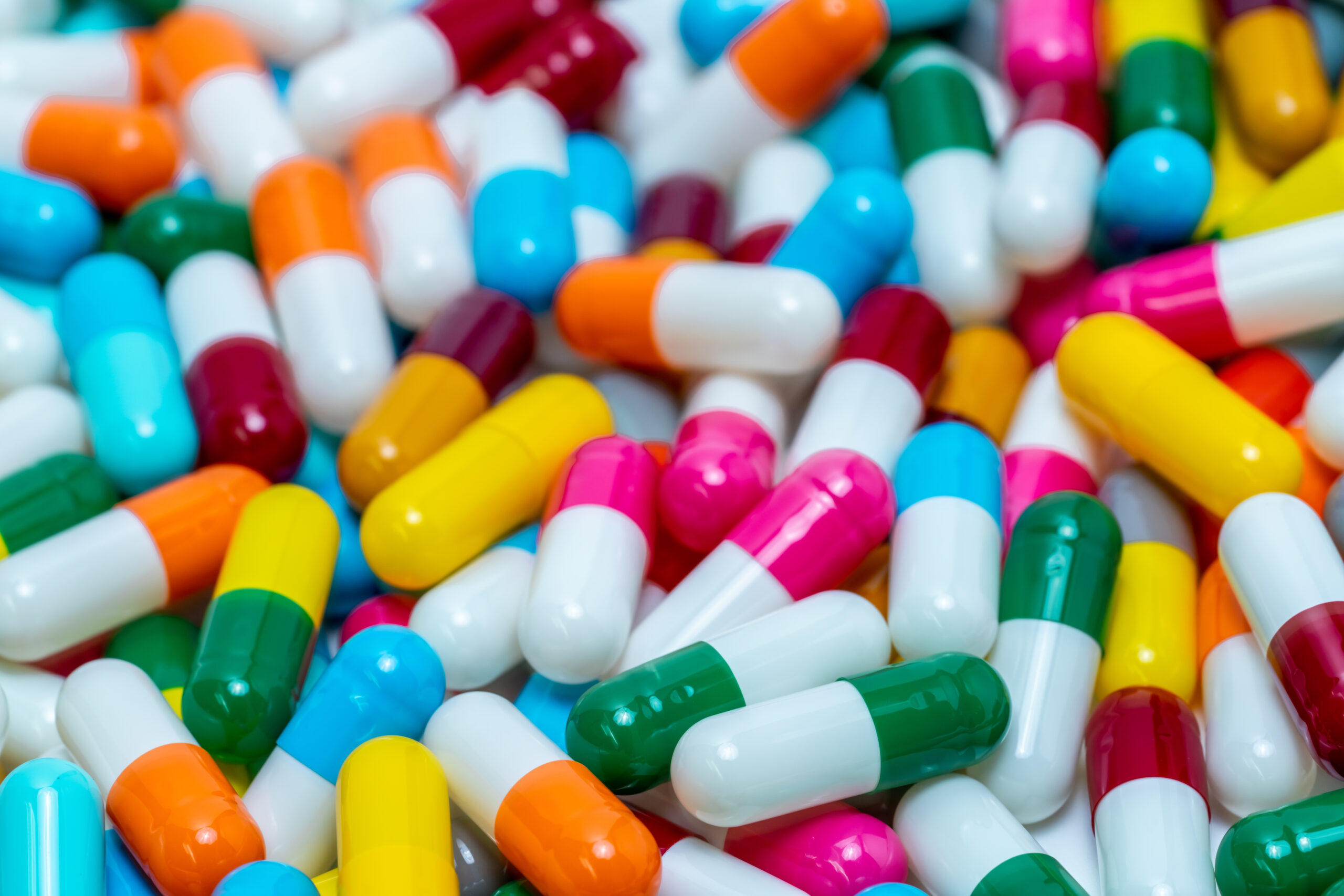 Selective focus on antibiotic capsule pills. Antibiotic drug resistance. Pile of bright colors capsule pills. Pharmaceutical industry. Pharmaceutical products for healthcare. Antimicrobial drugs.